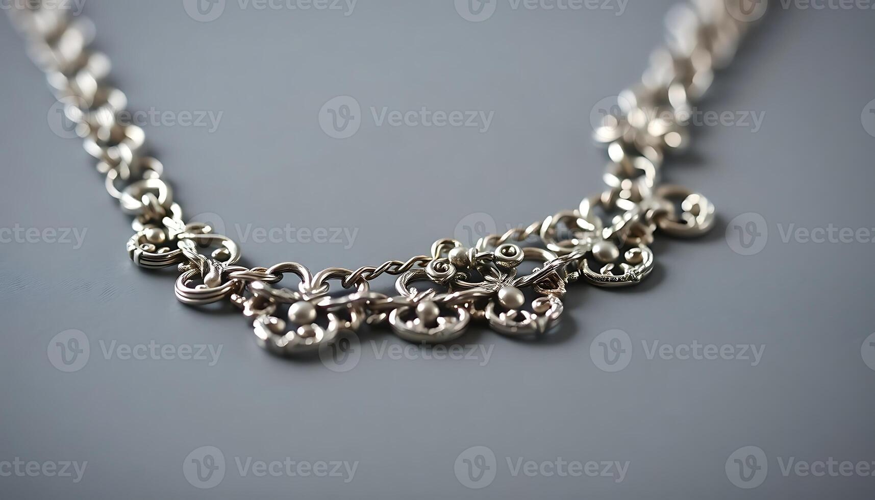 close up of a silver necklace on a gray surface photo