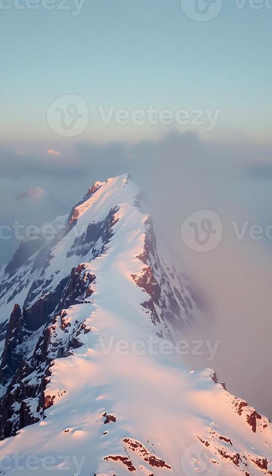 mountain covered in snow and clouds under a blue sky photo