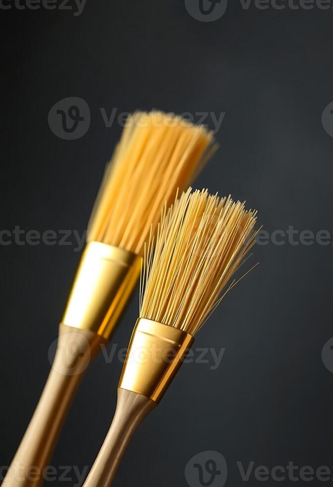 two gold colored brushes sitting next to each other photo