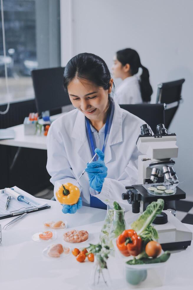 A woman in a lab coat is holding a piece of fruit photo