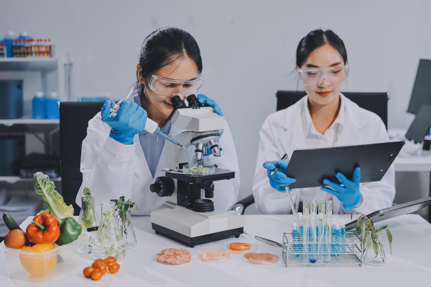 Two women in lab coats looking at a tablet computer photo