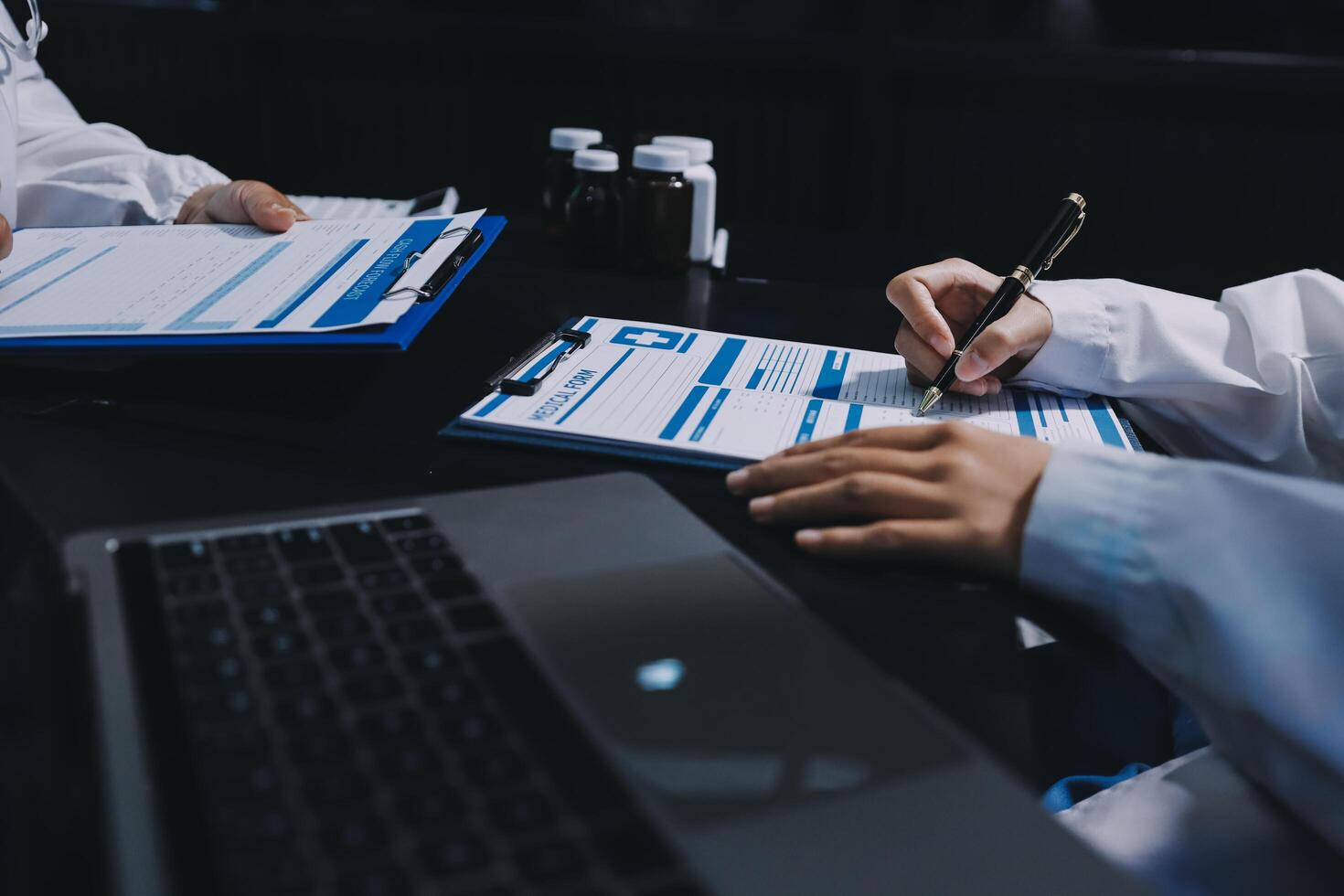 Two doctors working on paperwork at a table photo