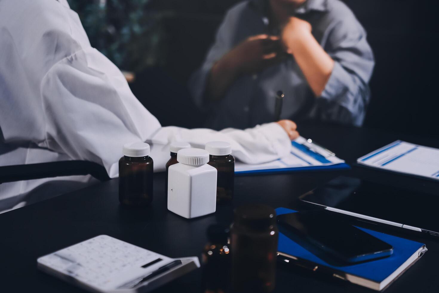 A woman sitting at a desk with a bottle of pills photo