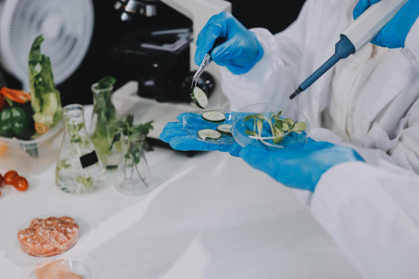 Scientist in lab coat and gloves preparing food for research photo