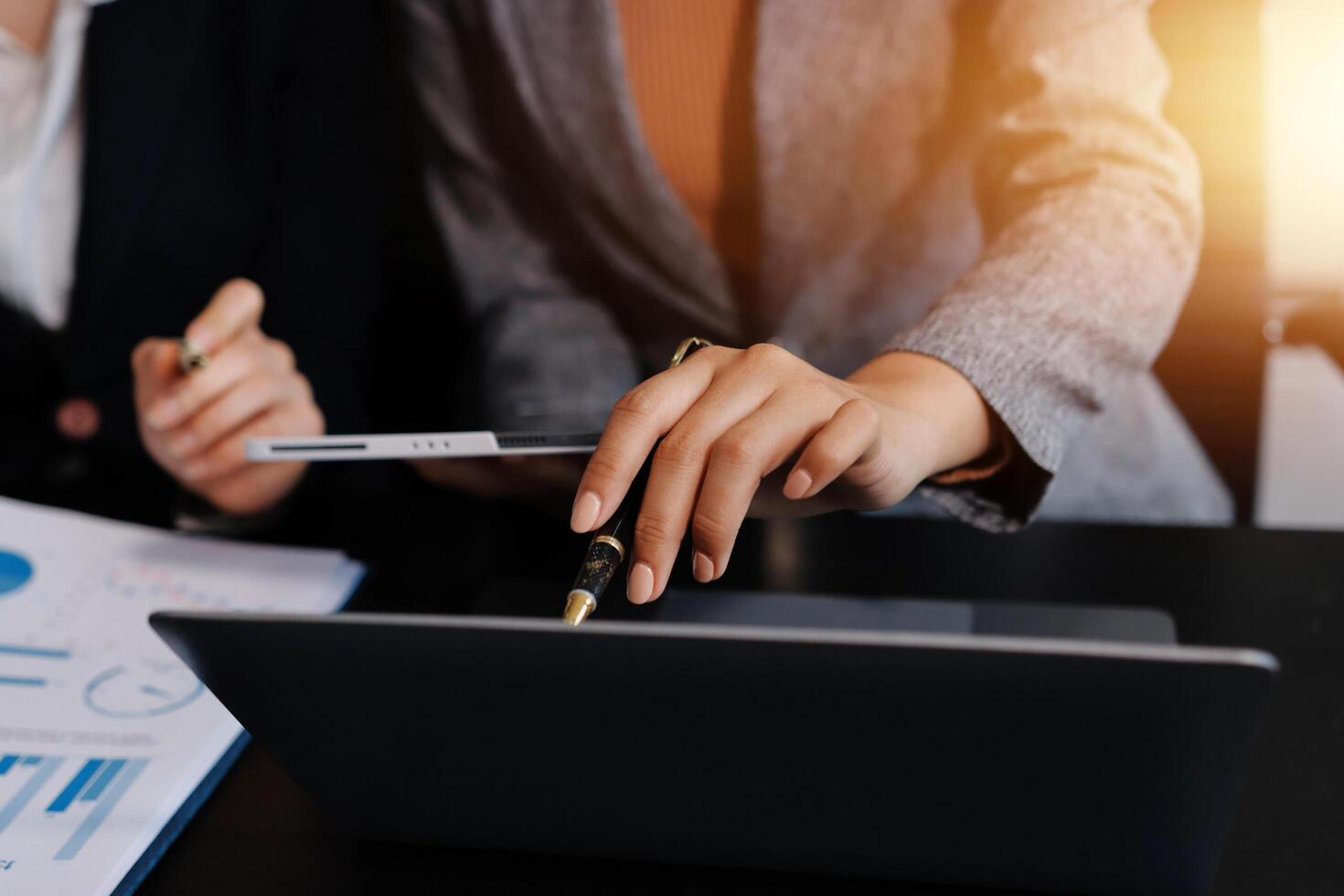 Two business people are using a laptop and pen photo