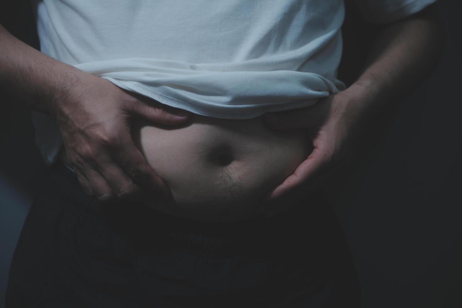 A man holding his stomach with his hands photo
