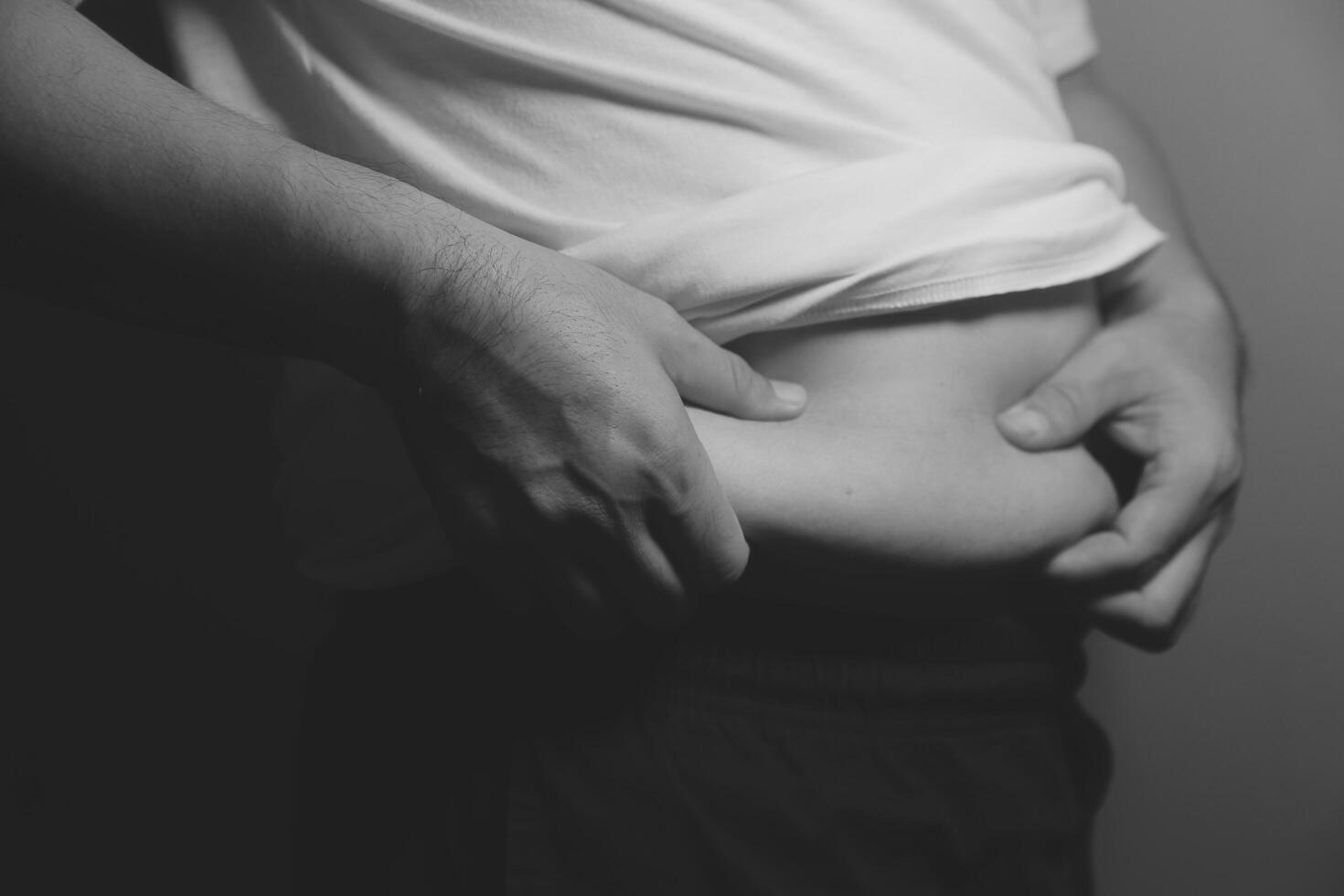 A man is holding his stomach in black and white photo