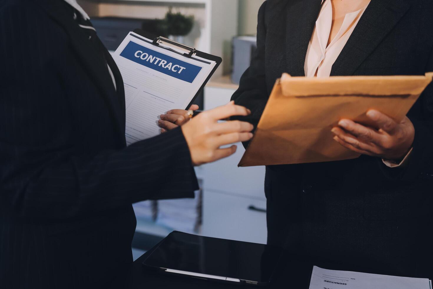 Two business people holding a contract photo