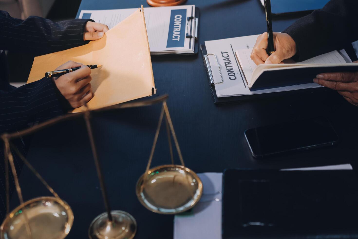 Two people at a desk with a scale and papers photo