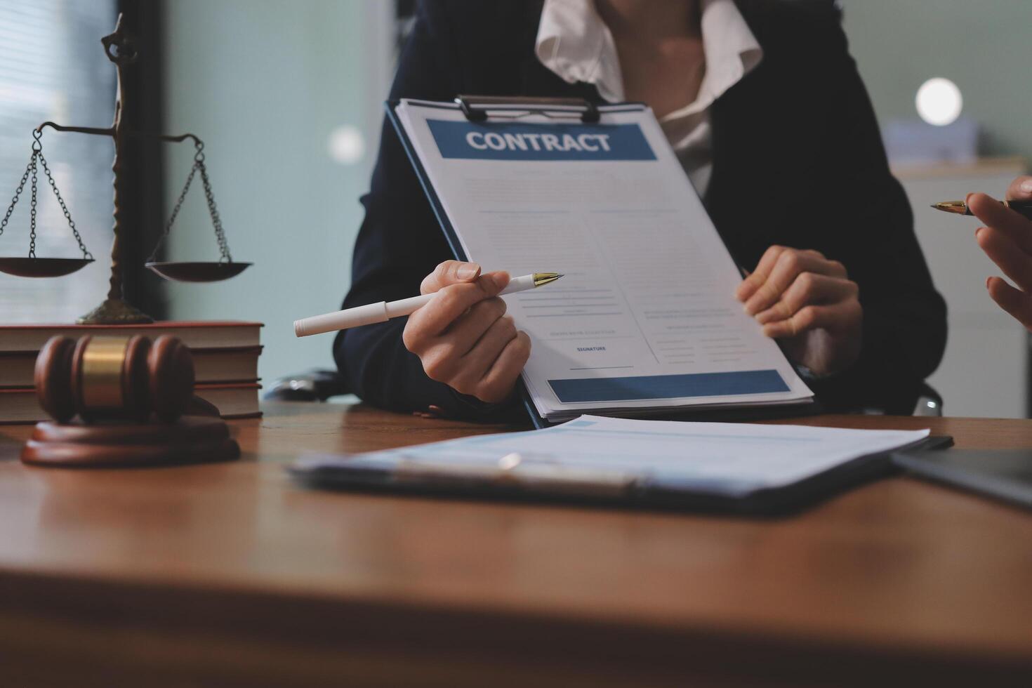 Two business people sitting at a desk with a contract photo