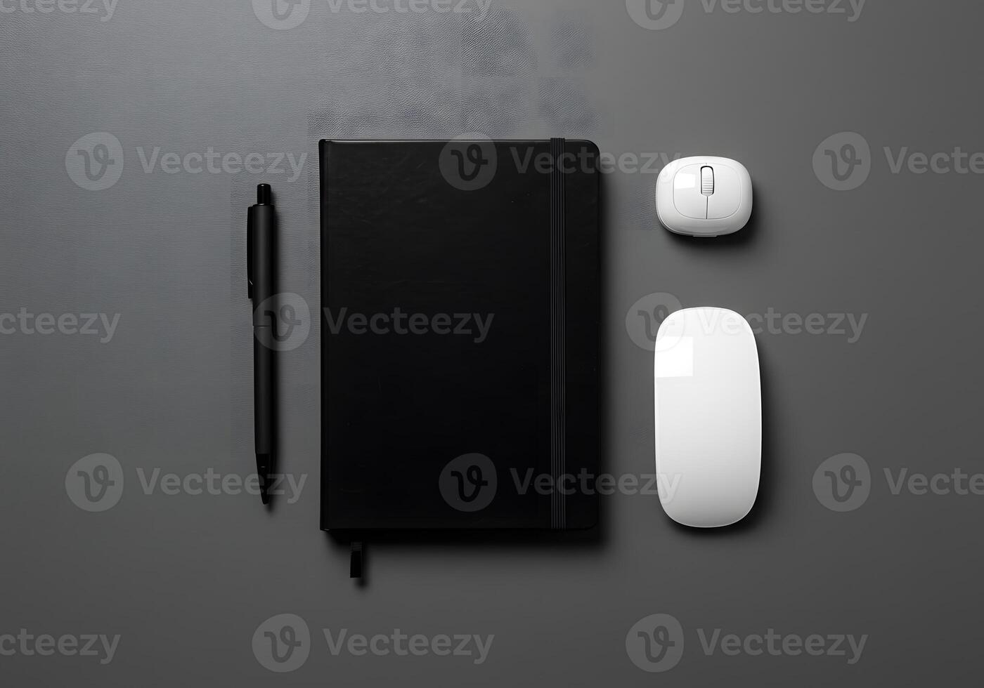 Overhead view of office supplies notebook pen and two computer mice on dark surface photo