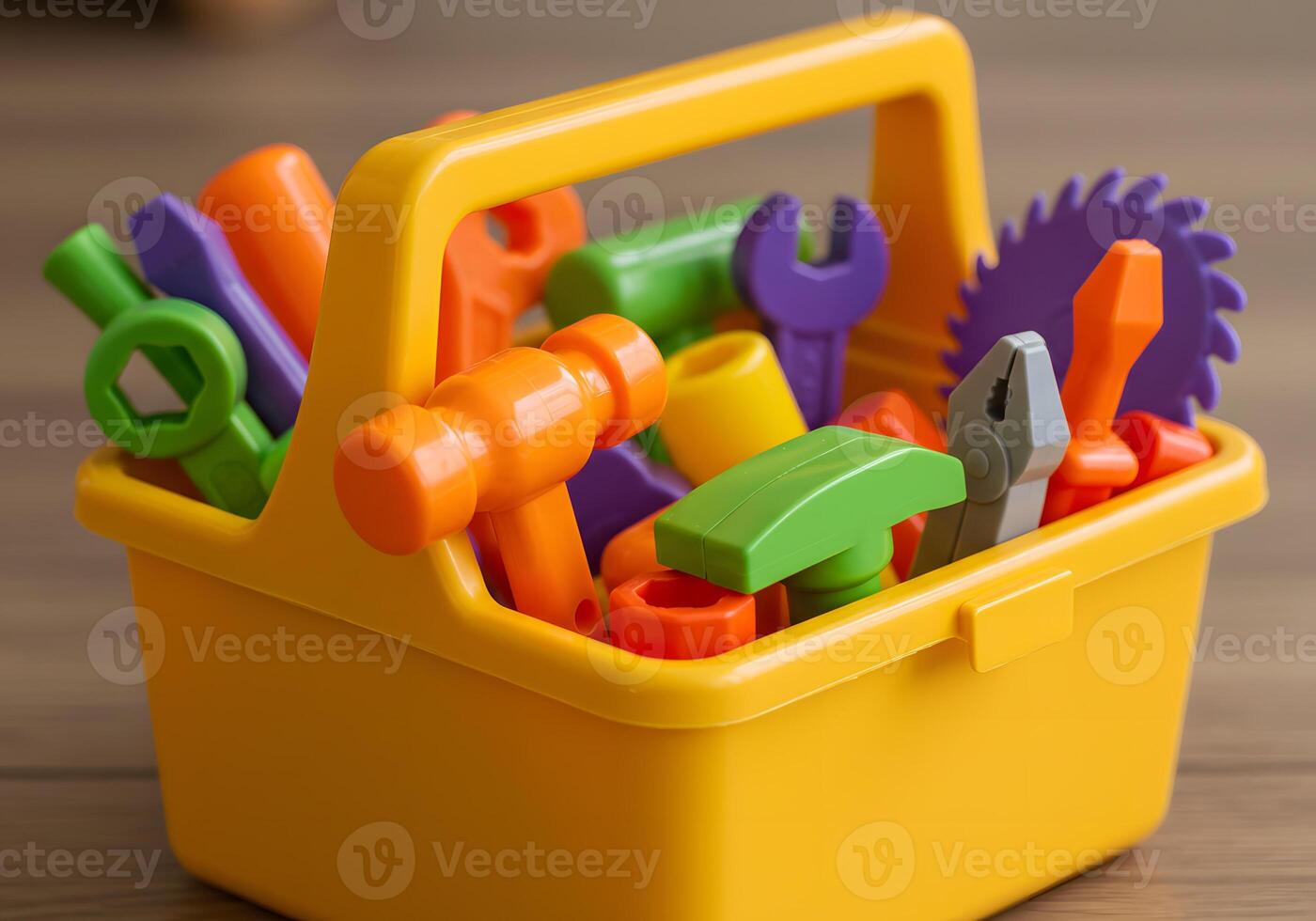 Close up of a yellow toolbox filled with toy tools on wooden surface photo