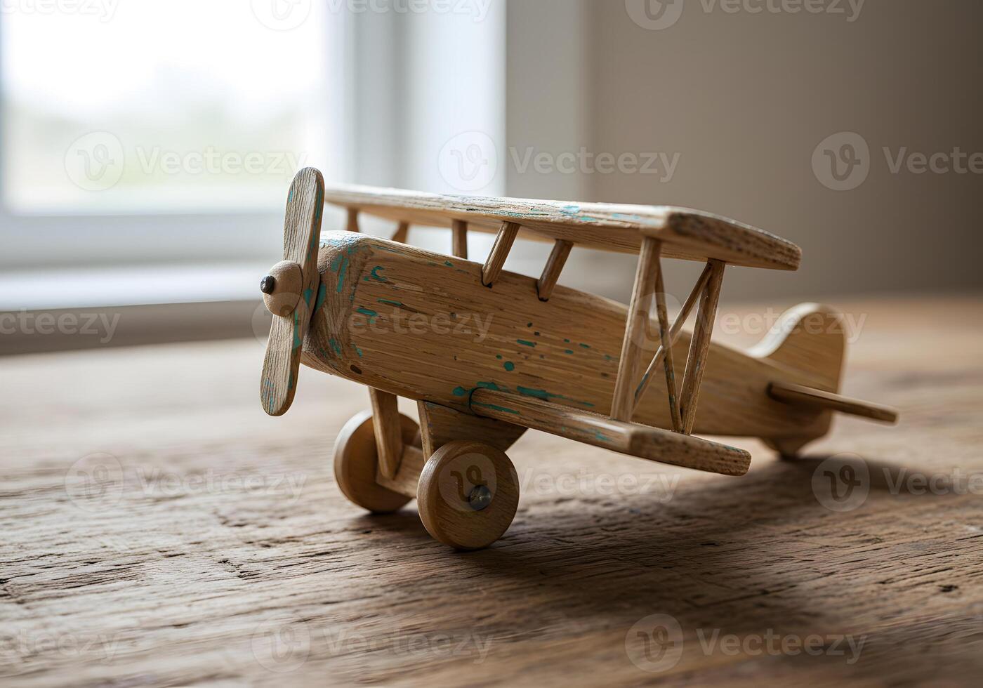 Wooden toy airplane on textured surface in natural light photo