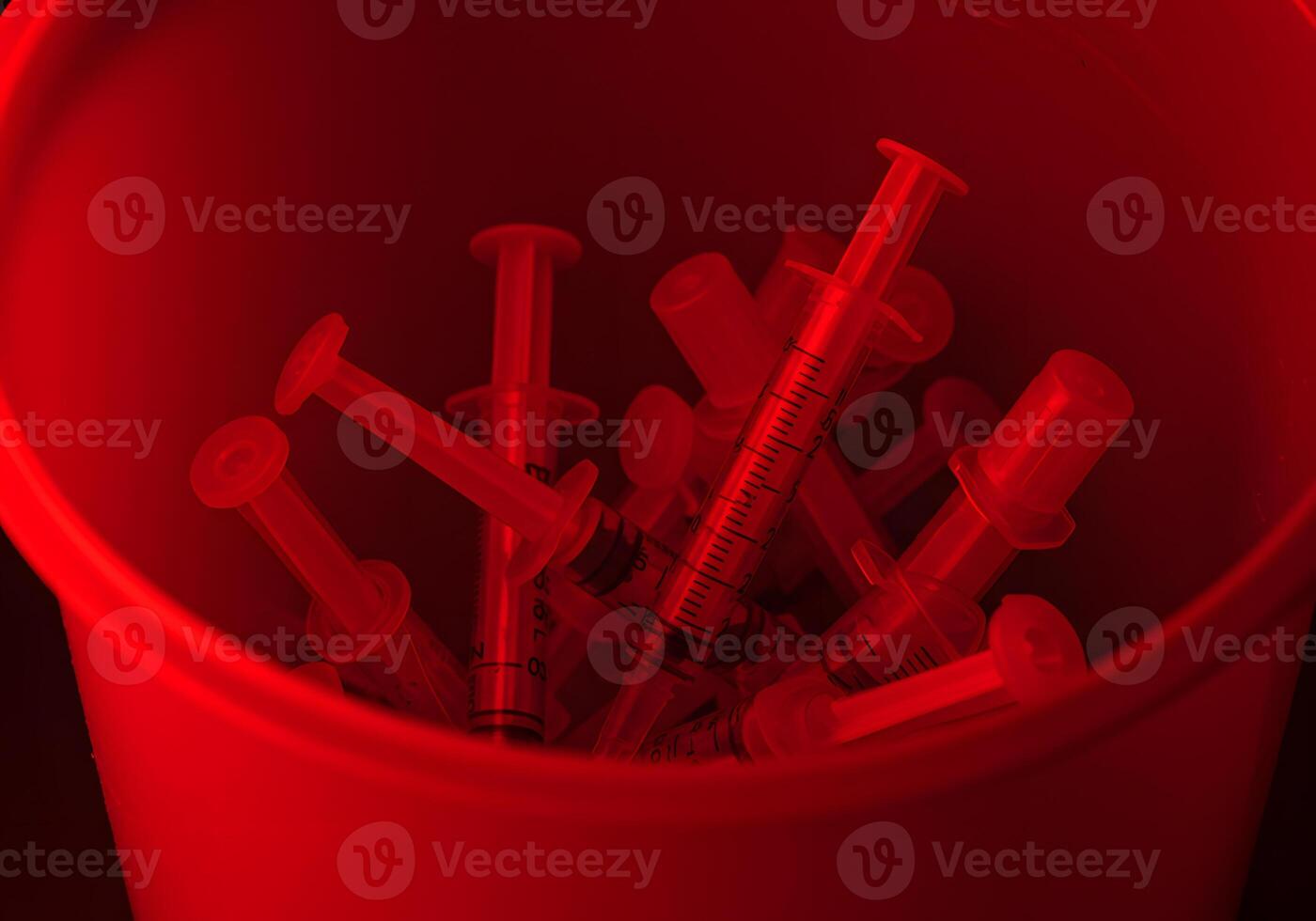 Red syringes in container photo