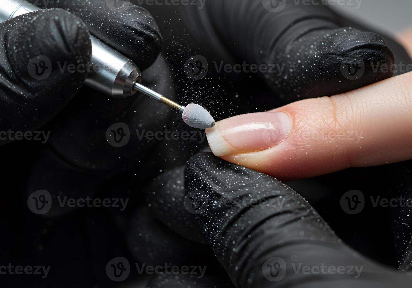 Manicurist filing nail with electric tool photo