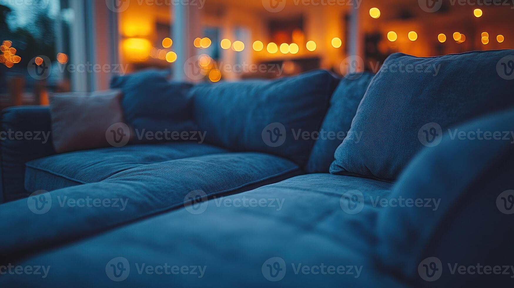 A blue couch is sitting in front of a window photo