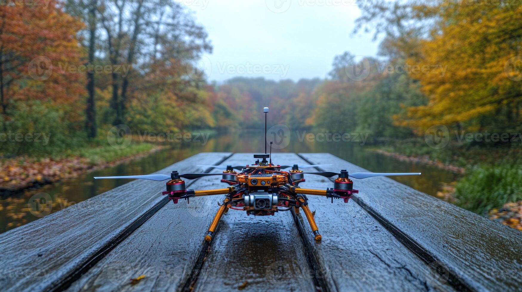 A small drone sitting on a wooden bridge in the fall photo