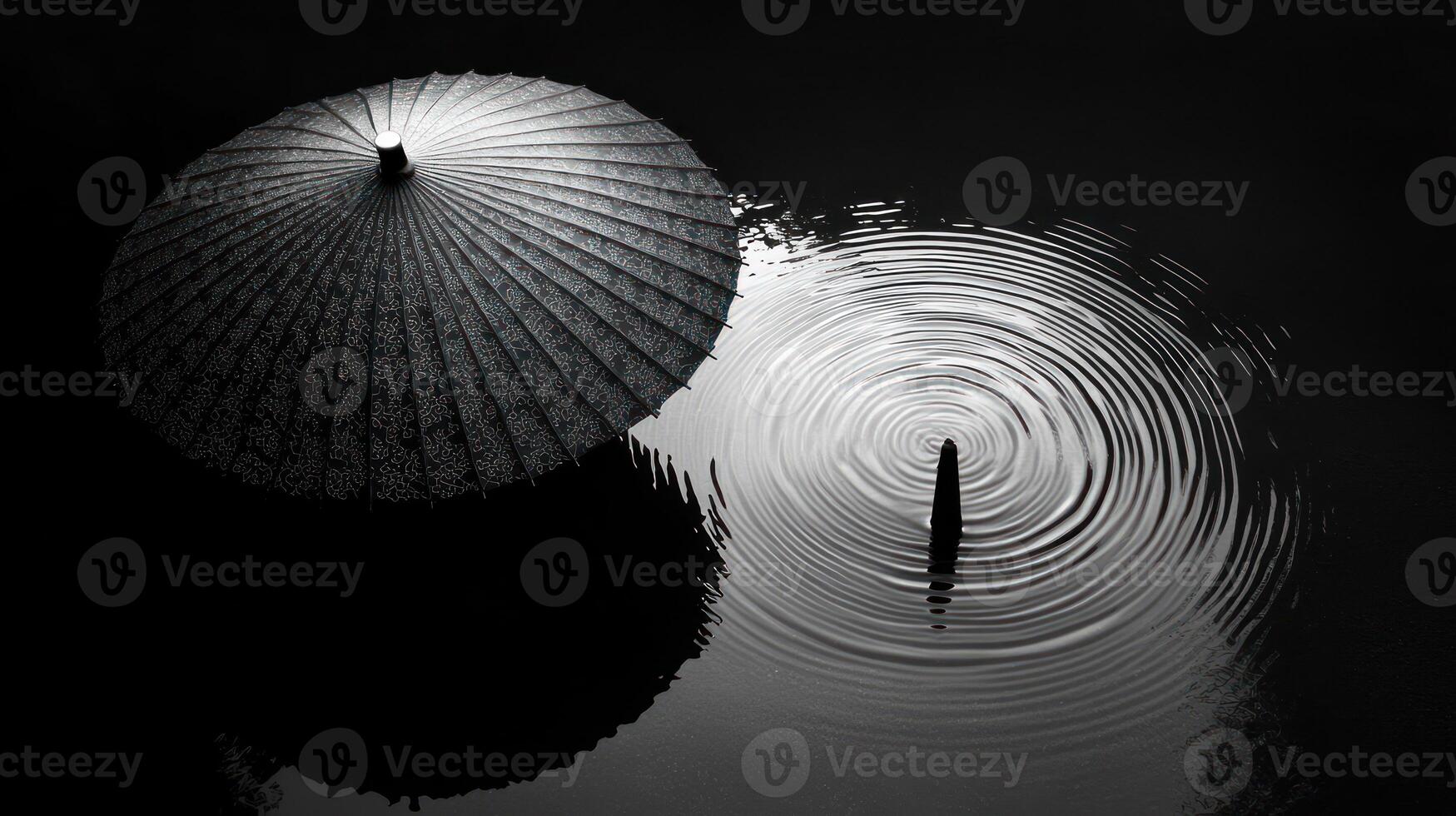 A black and white photo of an umbrella in the water