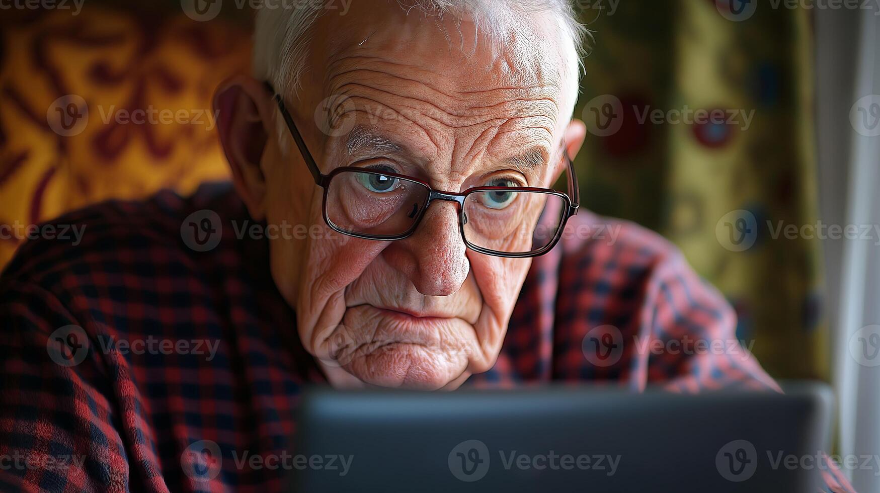 An old man with glasses looking at a laptop photo