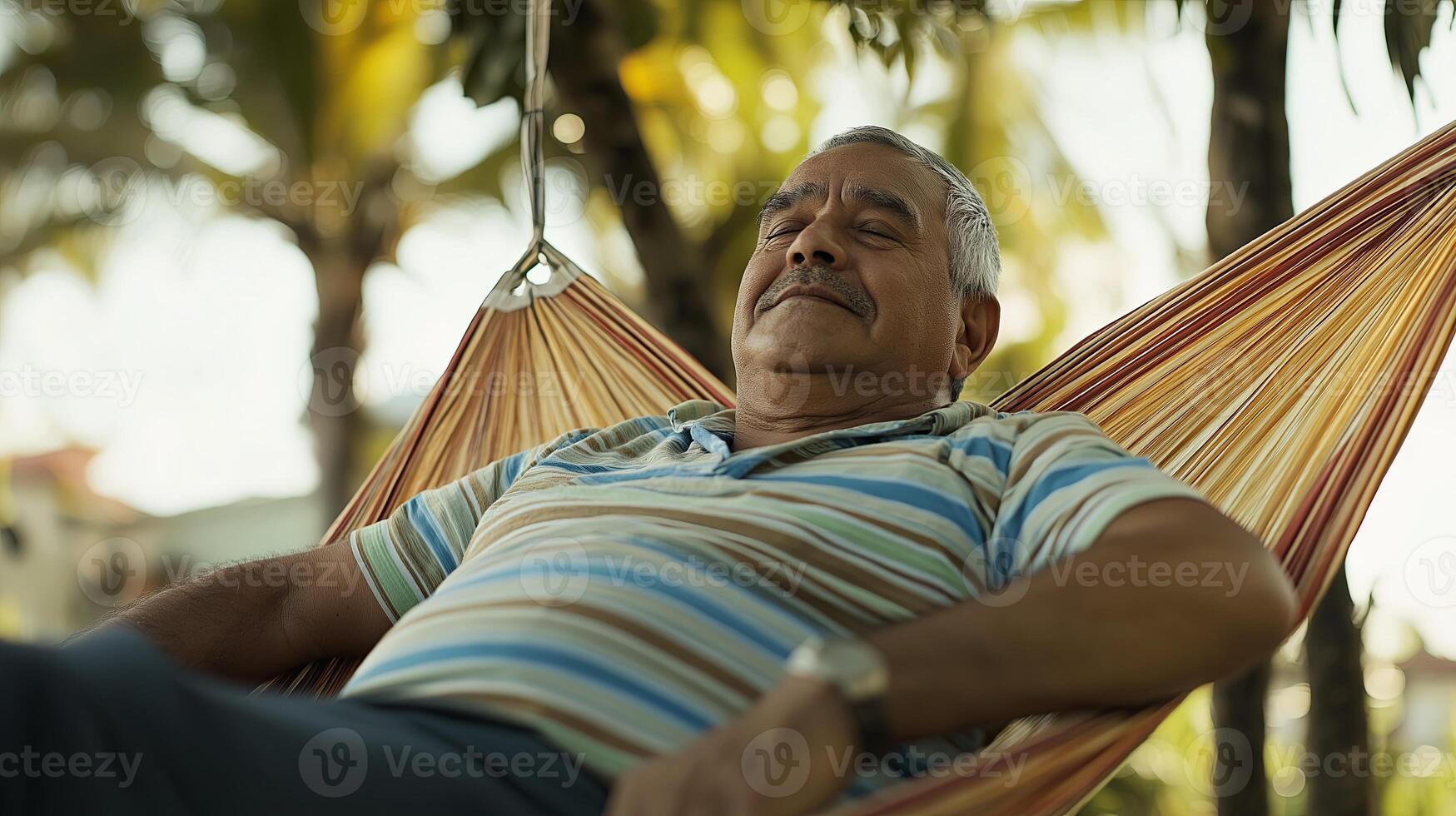 An older man is relaxing in a hammock photo