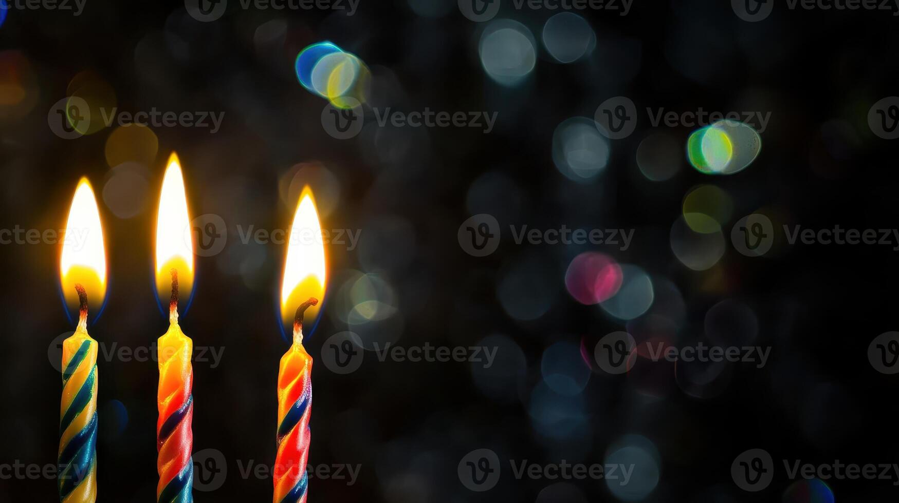 Three lit candles are in front of a dark background photo