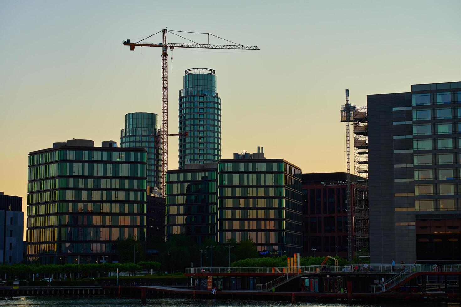 Copenhagen, Denmark, 2024 - Modern buildings and construction crane in Copenhagen at sunset photo