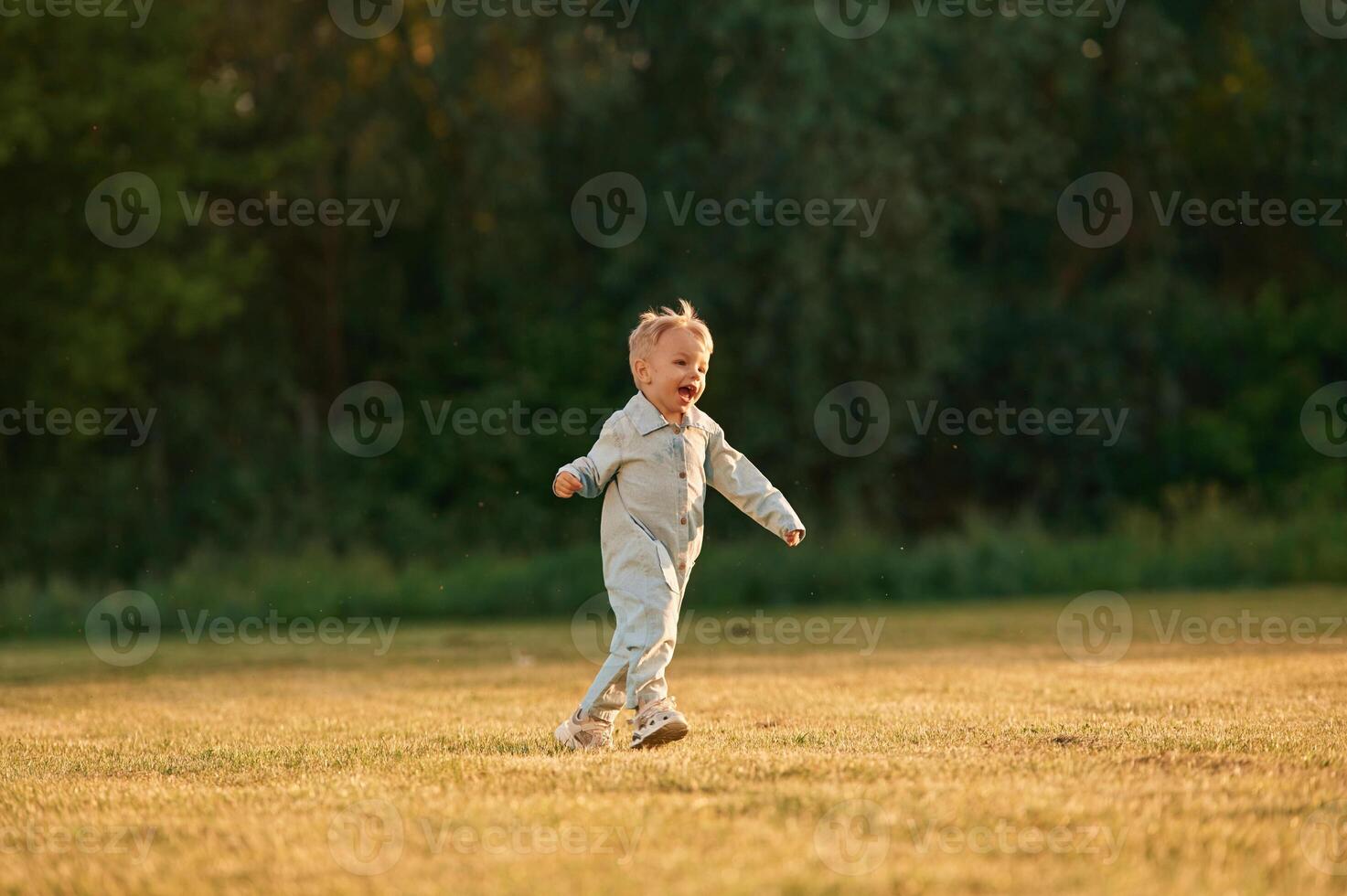 Having fun,,, running. Little boy is on the summer field photo