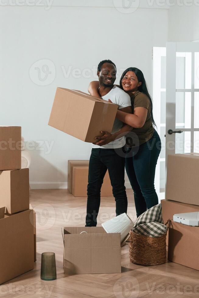 Holding boxes... African American couple are moving into new house photo