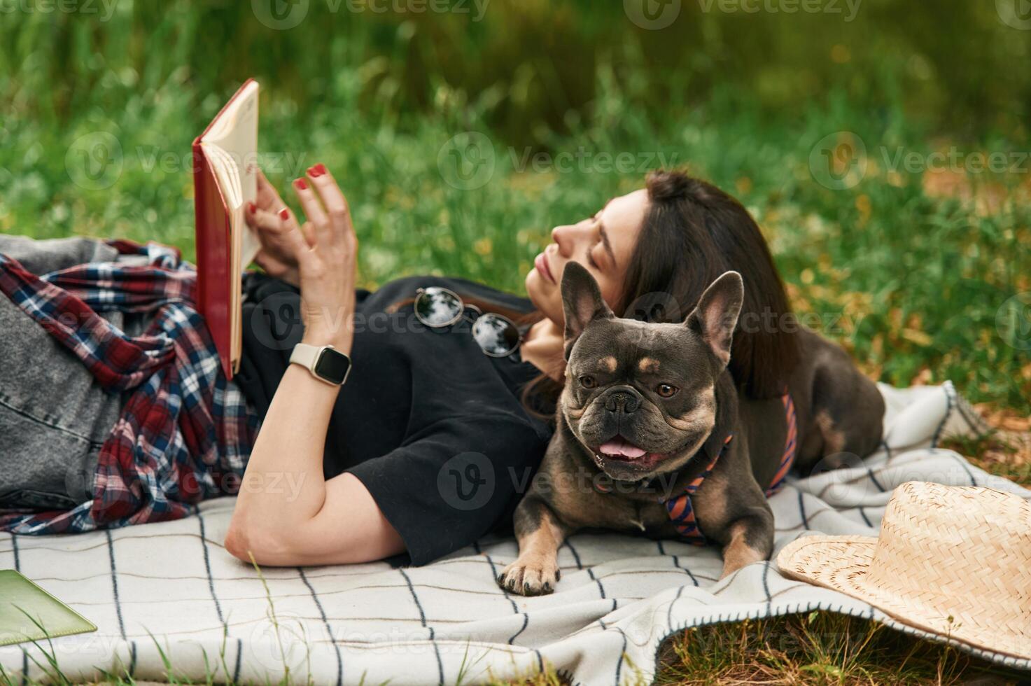 Lying ,down with book. Young pretty woman is with her dog in the park.,, photo