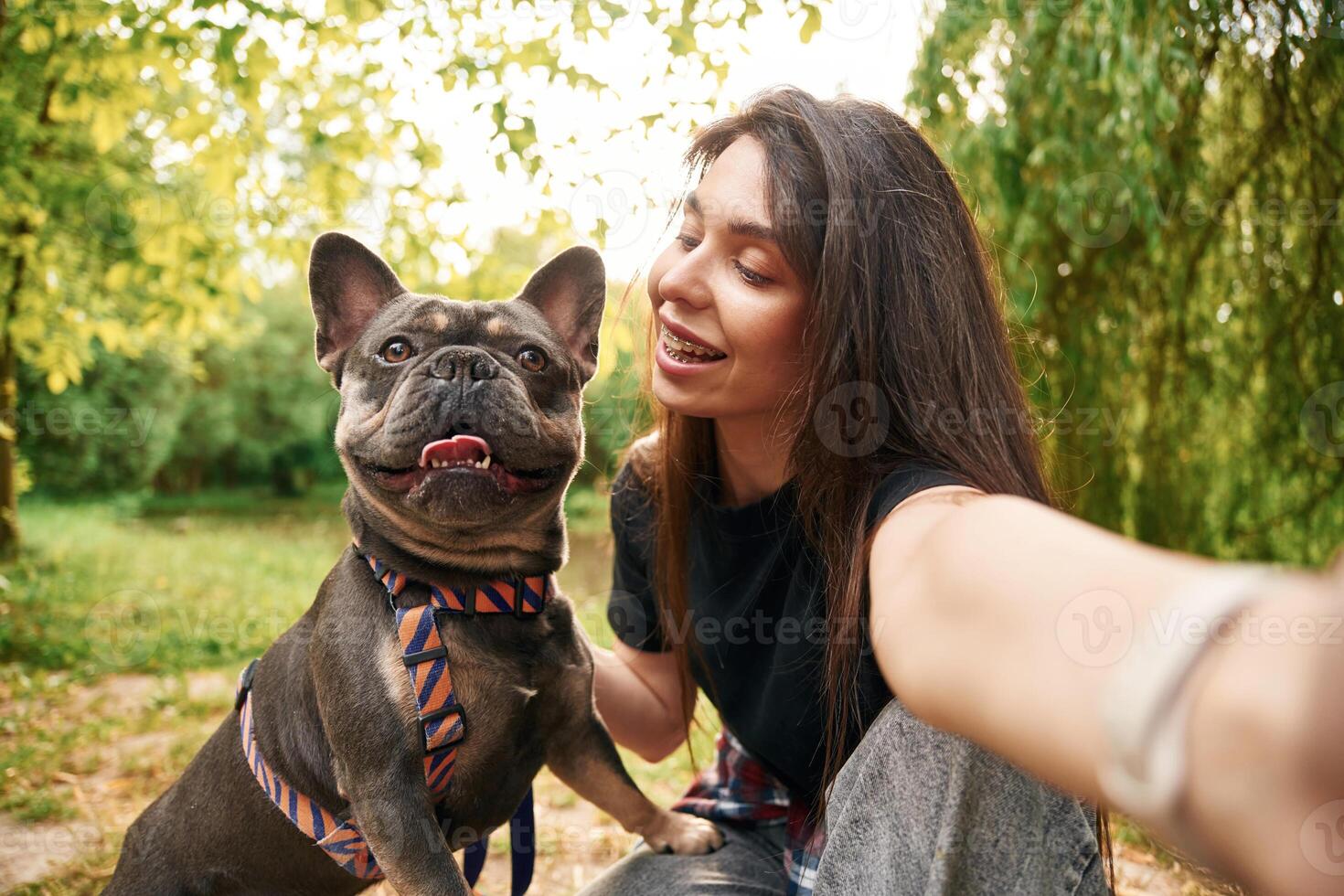Making a selfie. Young pretty woman, is, with her dog in the park photo