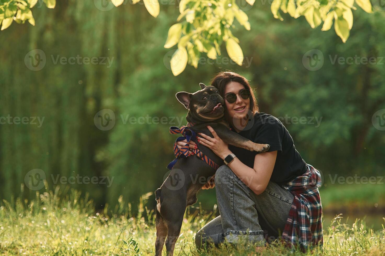 Playing on, the grass. Young pretty woman is with her dog in the park photo