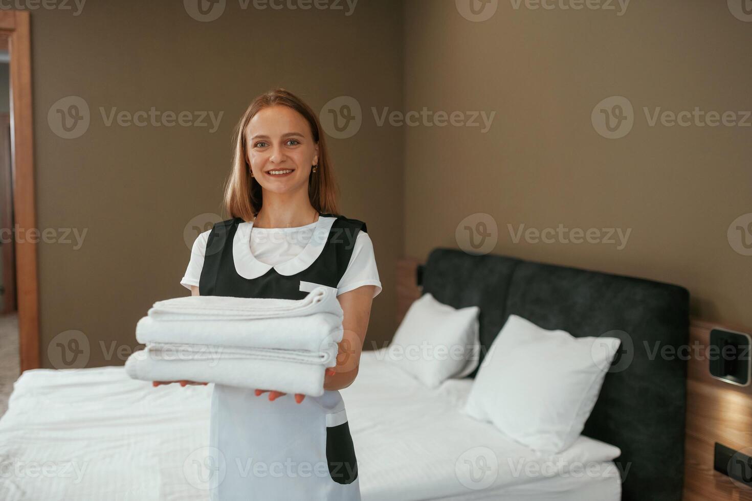 New fresh cloth. Young chambermaid is in hotel room photo