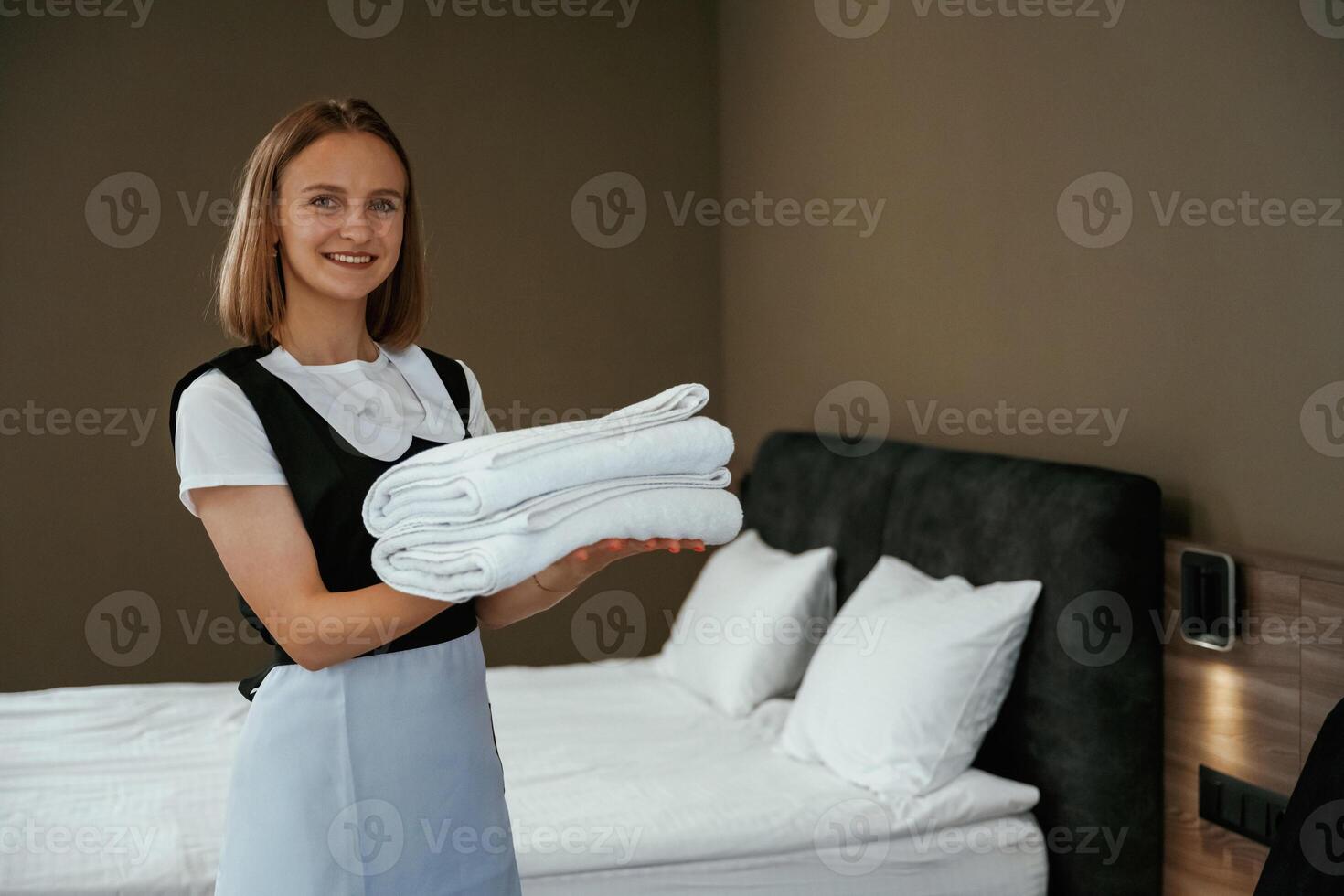 Beautiful woman. Young chambermaid is in ,,hotel, room photo