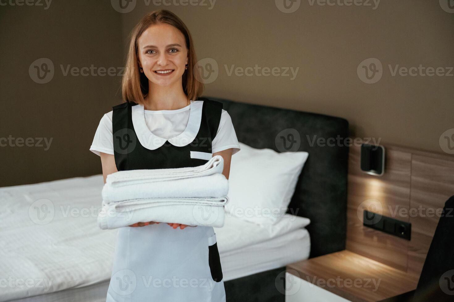 Modern ,,interior, working. Young chambermaid is in hotel room photo