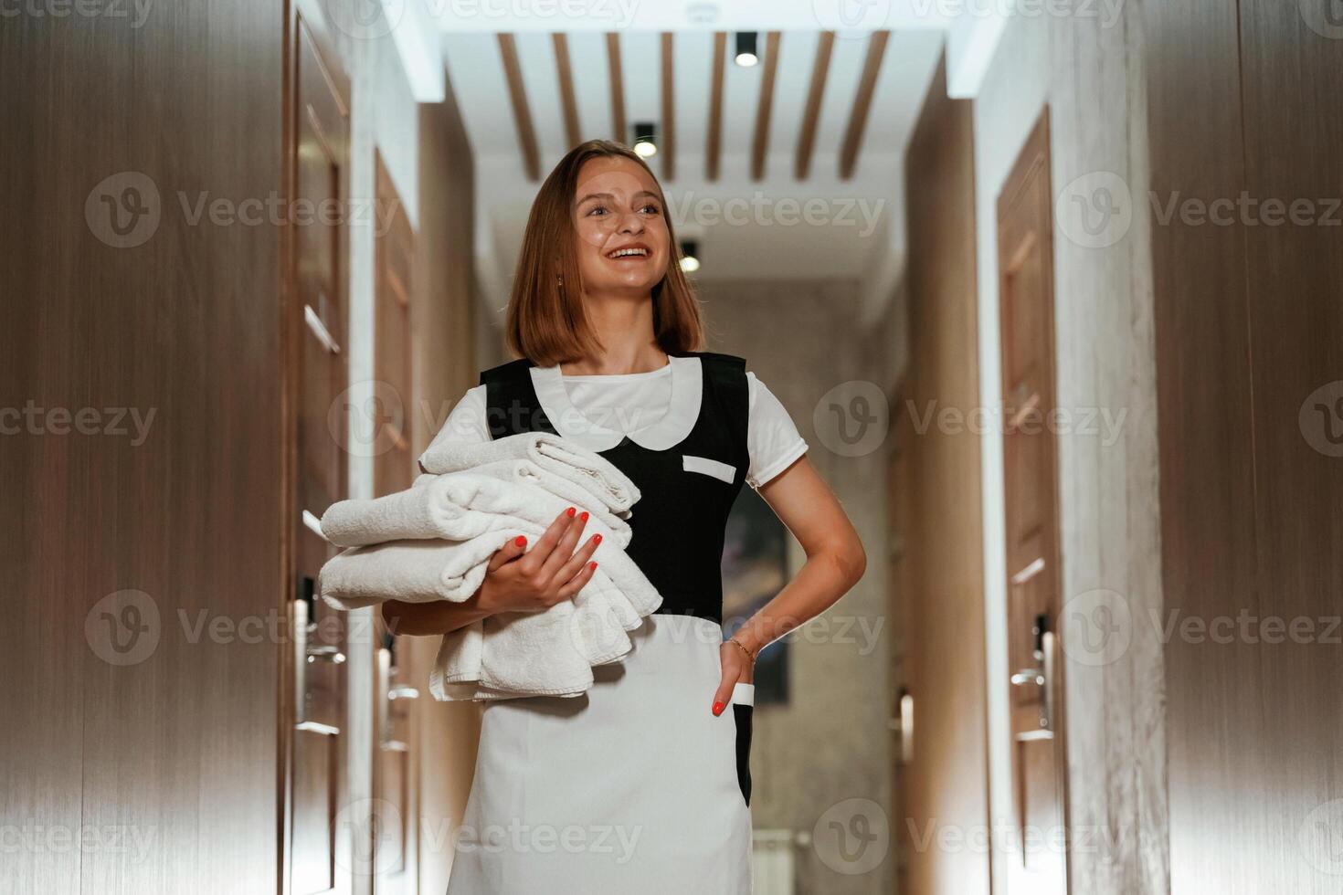 Front view,, with, fresh, cloth. Chambermaid is standing in the hotel corridor photo
