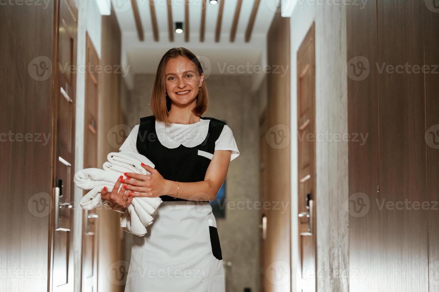 Between the, rooms. Chambermaid is standing in the hotel corridor photo