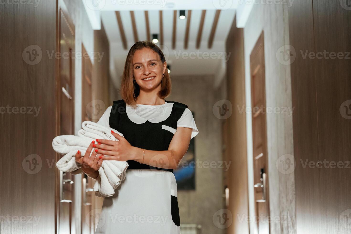 Between, the rooms. Chambermaid is standing in the hotel corridor photo