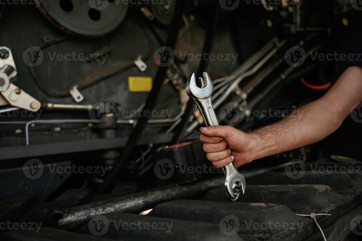 Close up, view... Mechanic's hand fixing machinery with wrench in workshop photo