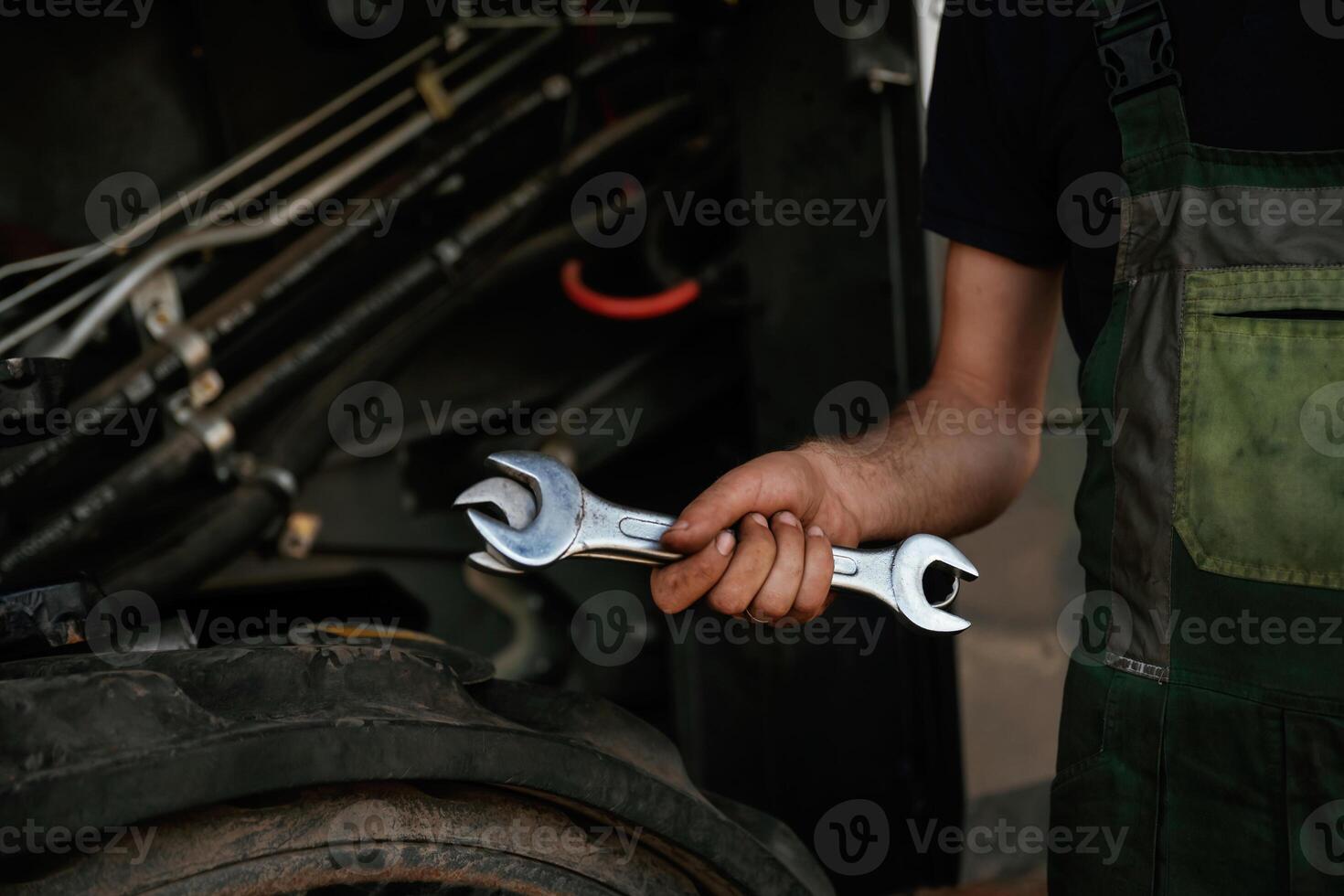 Close up view.. Mechanic's,, hand fixing machinery with wrench in workshop photo