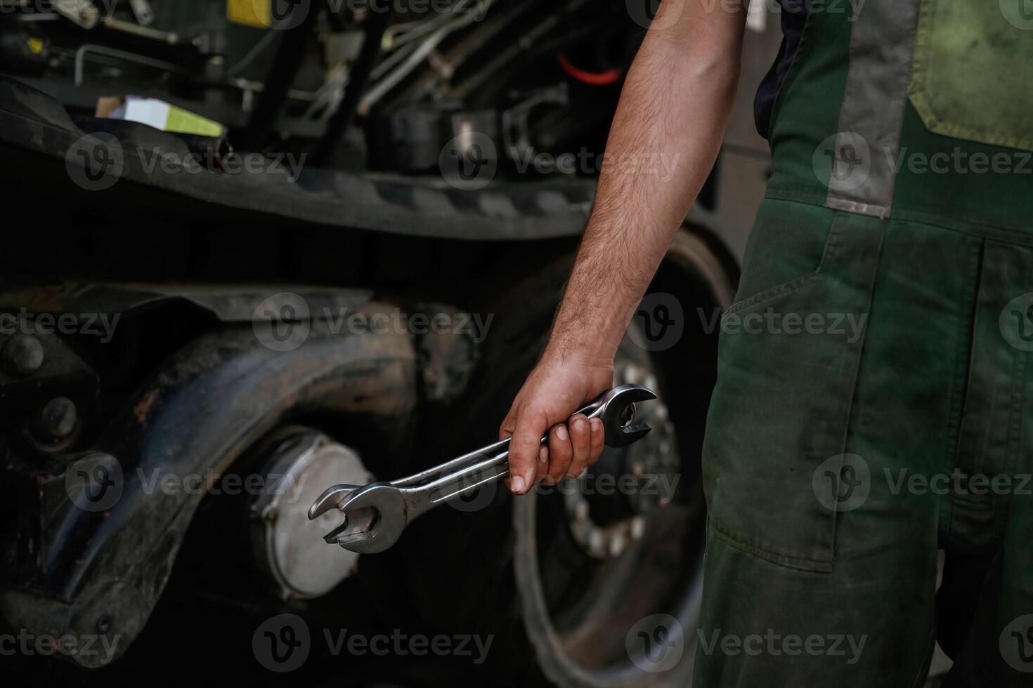 Holding, wrench. Mechanic's hand fixing machinery in workshop., photo