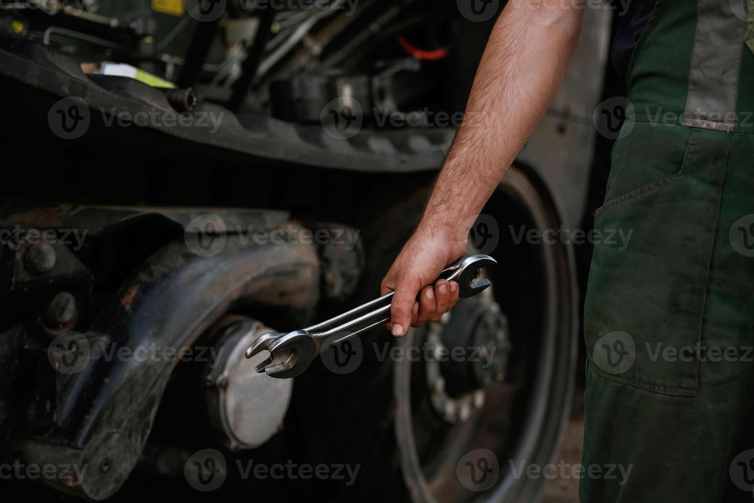 Holding wrench. Mechanic's ,hand fixing machinery in workshop photo