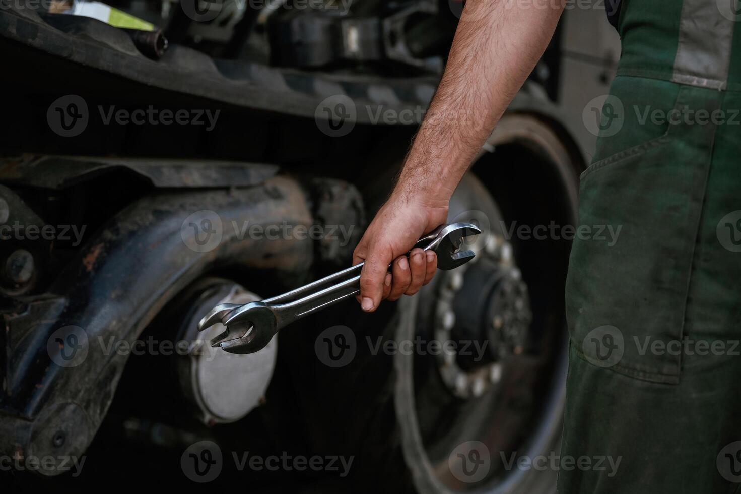 Holding, wrench. Mechanic's hand fixing machinery in workshop. photo