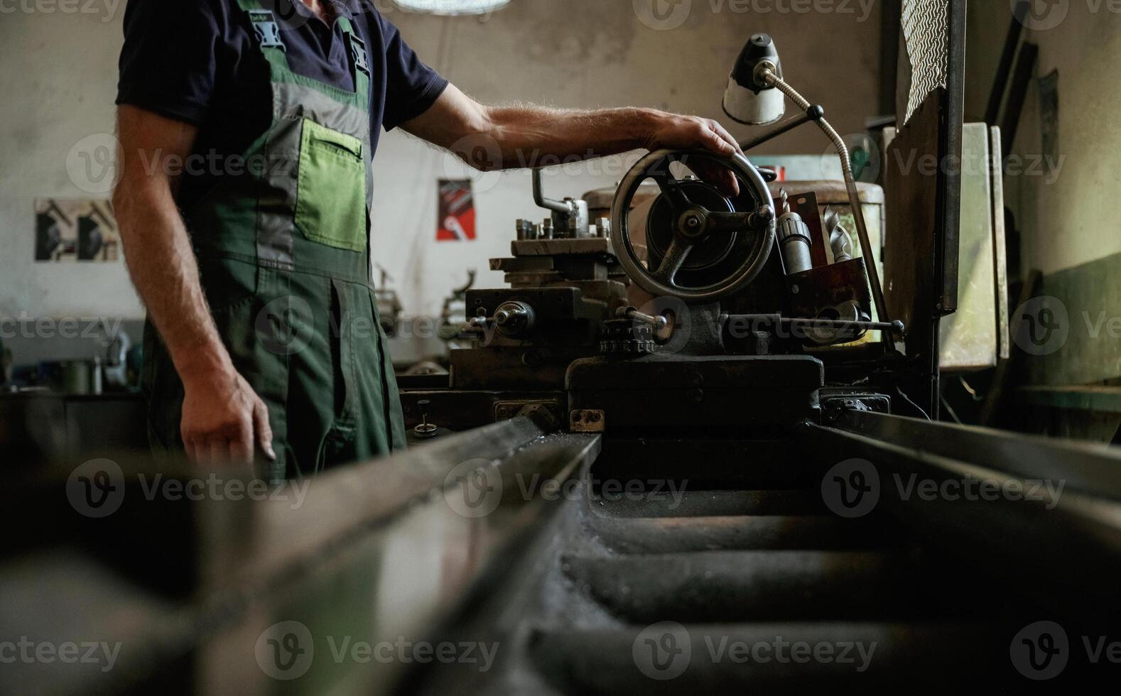 Side view. Close-up of, worker's hands operating industrial machinery in workshop photo