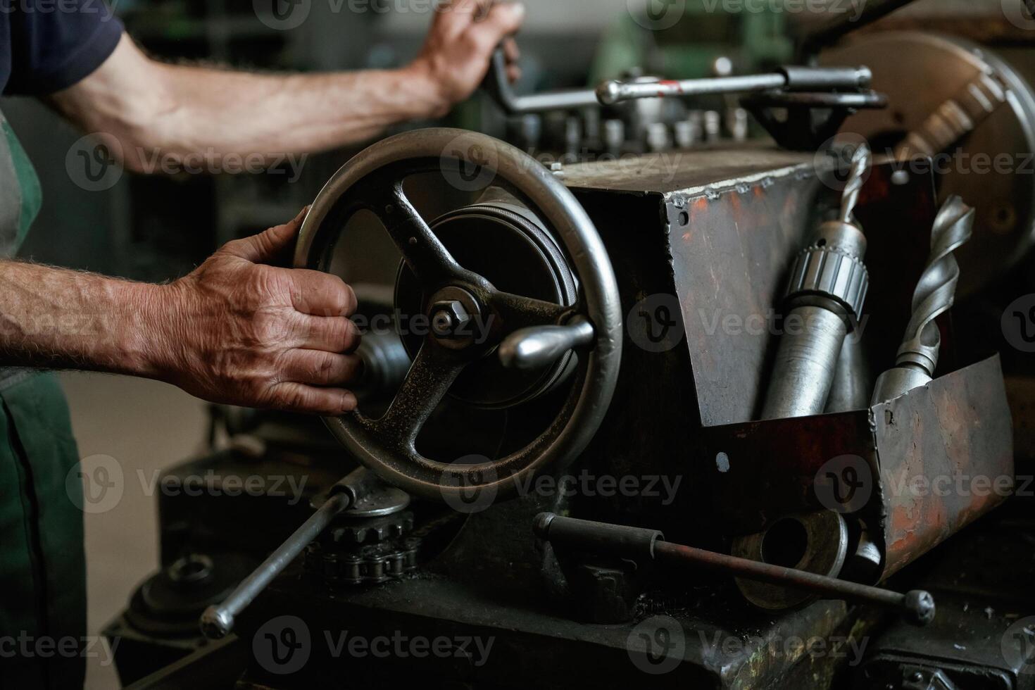 Close-up of worker's hands, operating industrial machinery in workshop photo