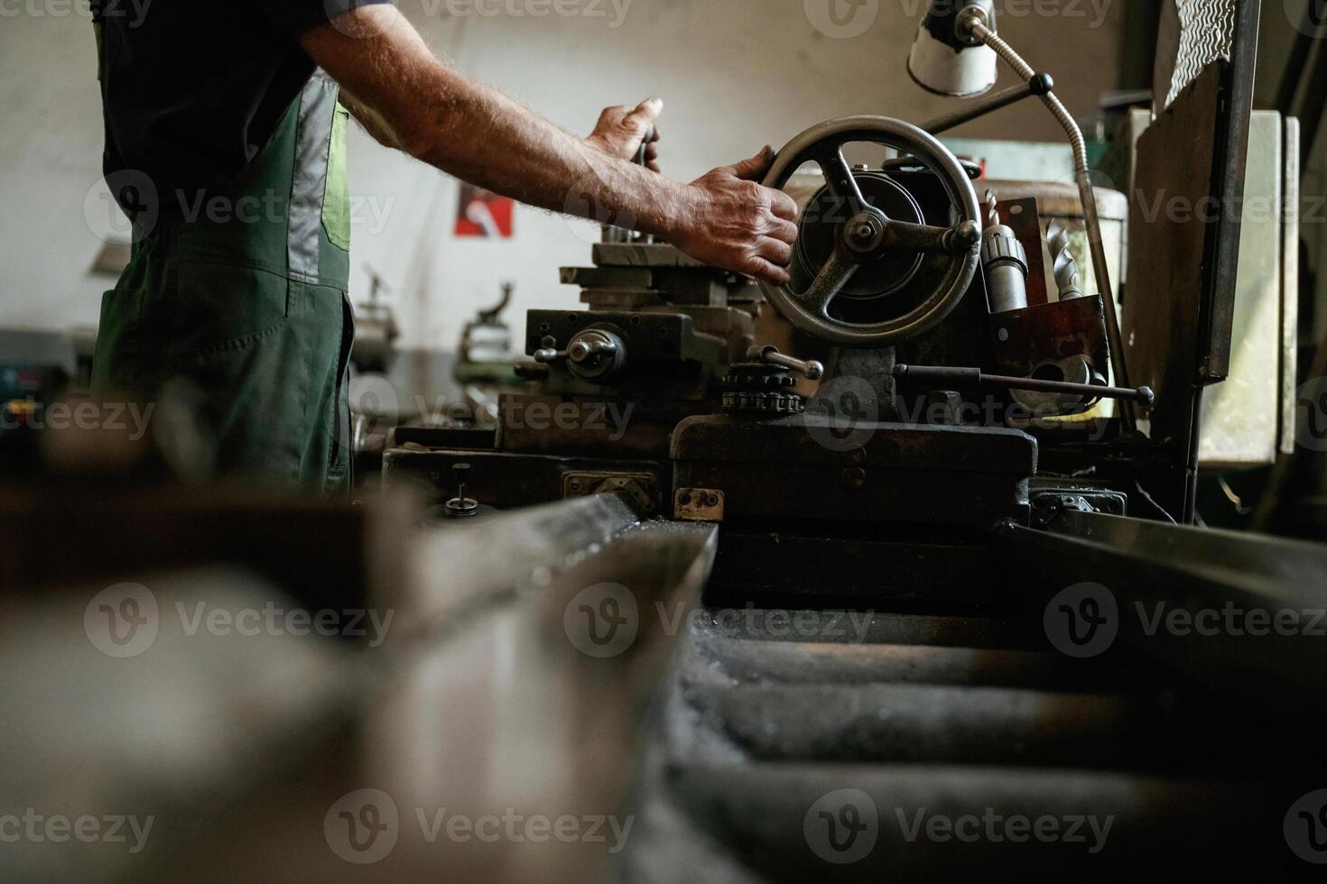 Side ,view. Close-up of worker's hands operating industrial machinery in workshop photo