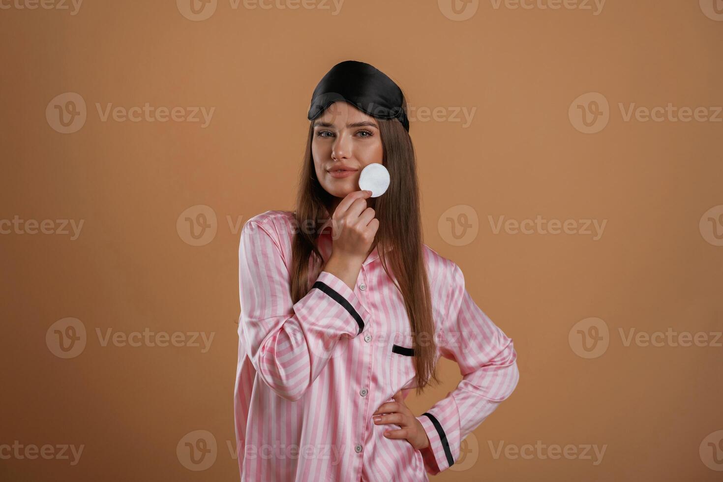 Skin care morning ,routine,, in pink pajama. Young pretty woman is against background in the studio photo