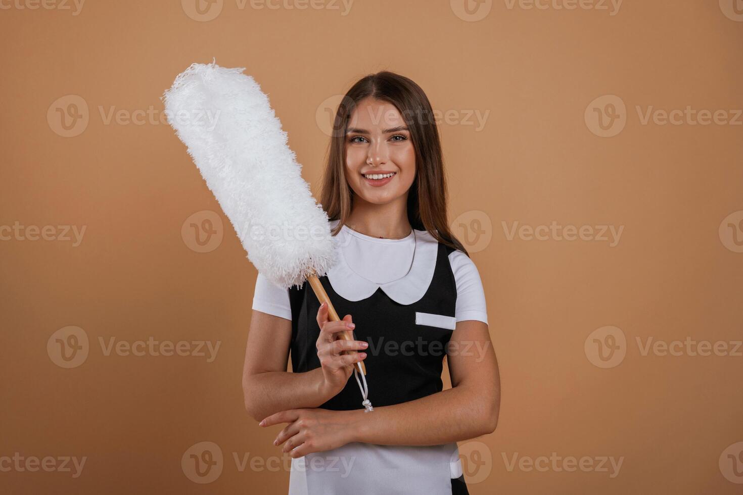 Big white cleaning ,thing in hand. Young pretty woman is against background in the studio photo