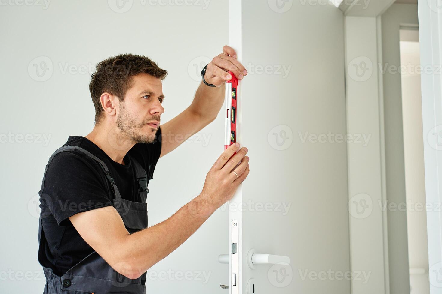 Man using level to align door frame during installation photo