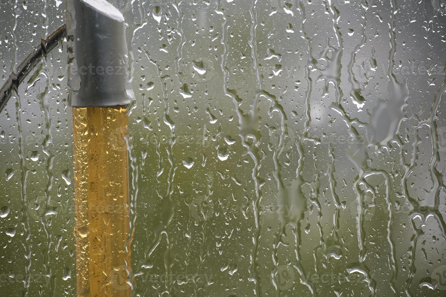 Raindrops run down a window, creating a beautiful abstract and watery scene. photo