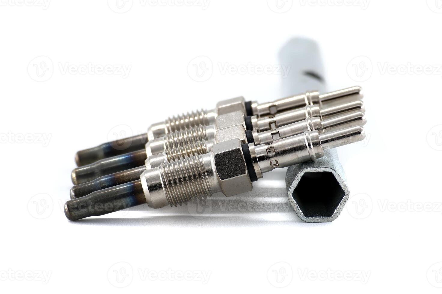 Automotive glow plugs with a wrench isolated on white background, detailed mechanical view. photo